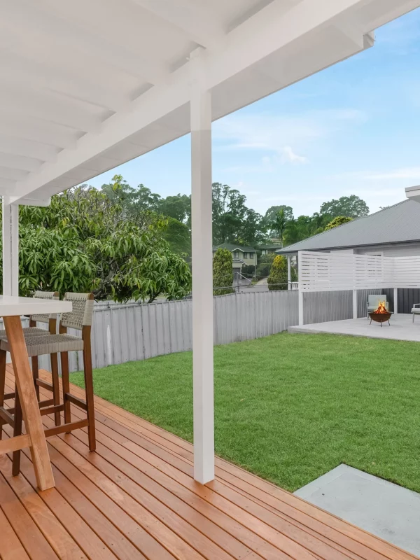 Elevated wooden deck with outdoor dining area overlooking landscaped garden