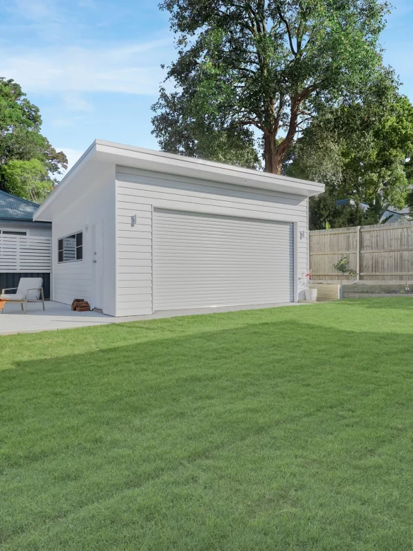 Cozy backyard fire pit area next to modern backyard shed with roller doors